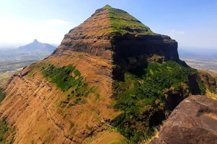 The pyramidal summit ridge of Salher Fort, the highest fort in Maharashtra, with layered basalt cliffs above the Baglan plains