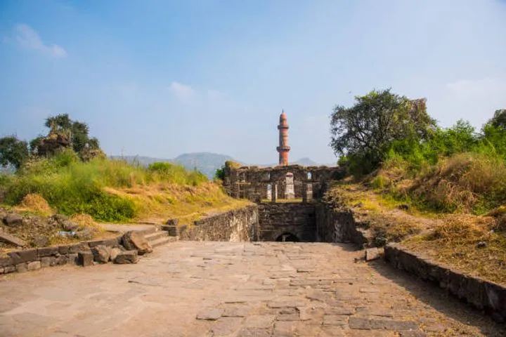 The conical hill of Daulatabad Fort crowned with fortifications and the Chand Minar tower below